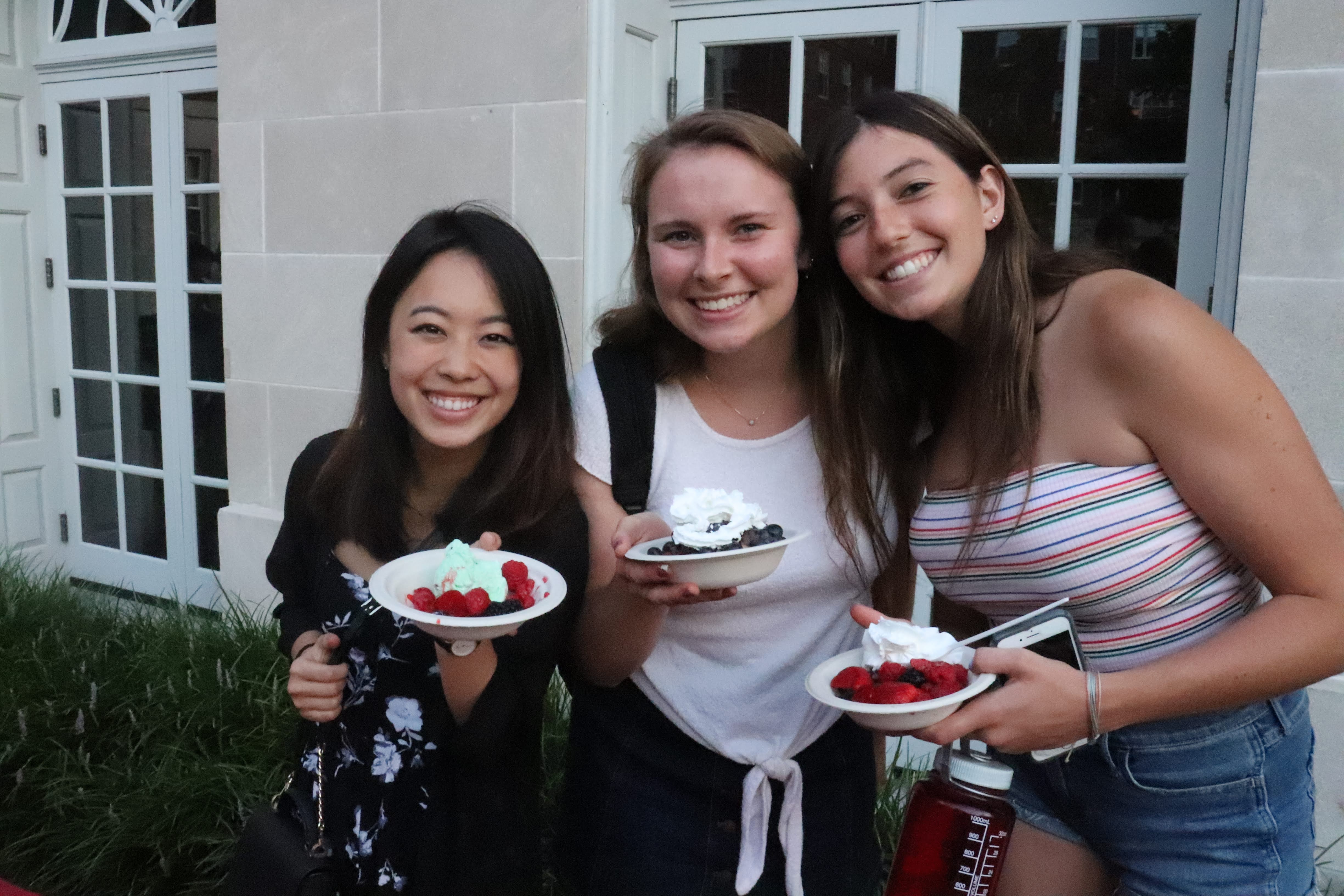 students holding berries and whipped cream