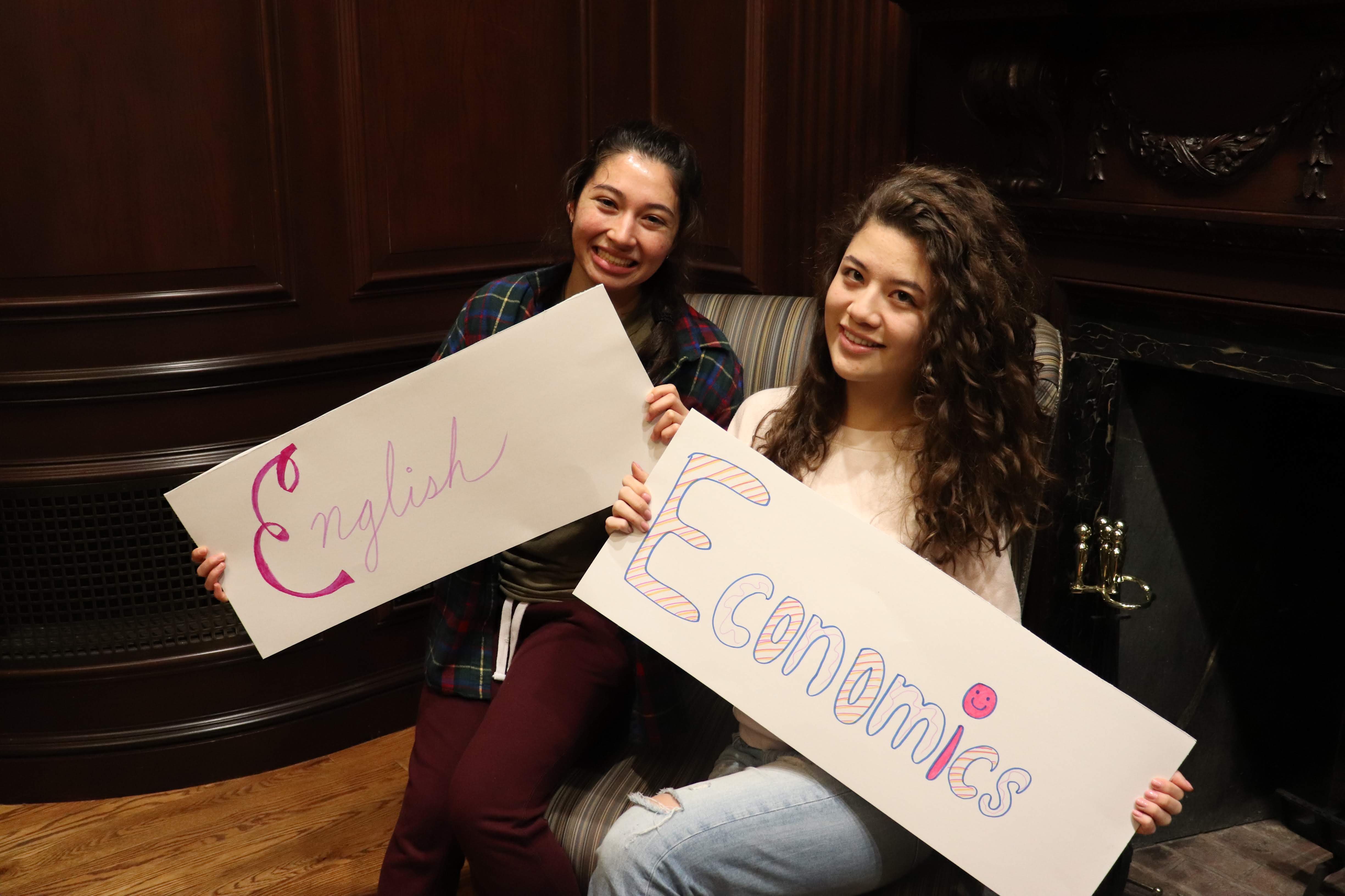 students holding signs with the names of their concentrations
