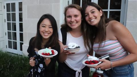 students holding berries and whipped cream