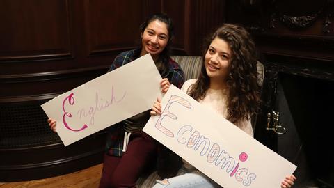 students holding signs with the names of their concentrations